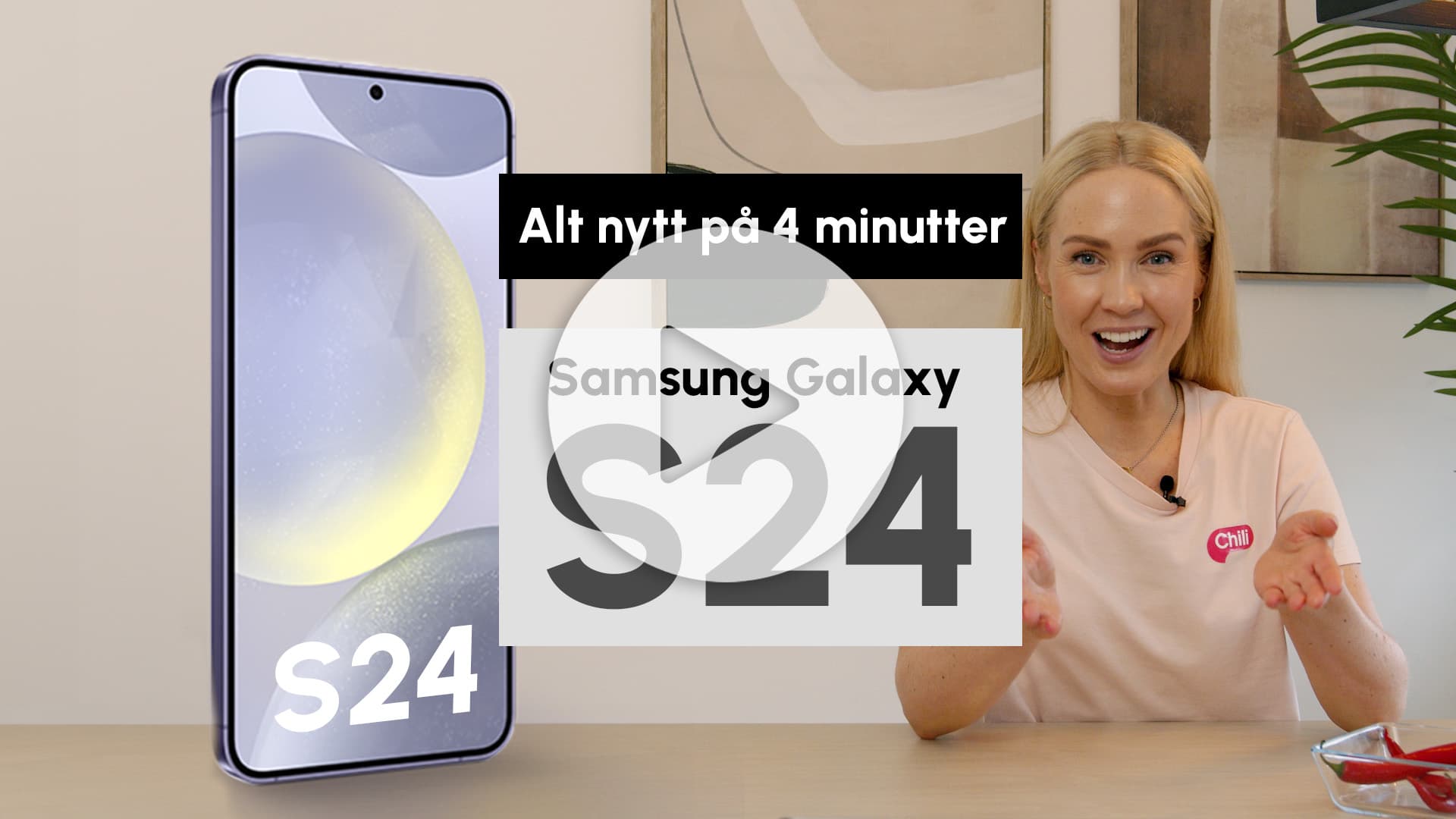 Bildet viser en kvinne som er smilende og presenterer en mobil i et videoformat. Det er en stor tekst som sier "Alt nytt på 4 minutter", som antyder at videoen er en rask gjennomgang eller oppdatering. En annen tekst som sier "Samsung Galaxy S24" tyder på at smarttelefonen som vises er den nyeste modellen fra Samsungs Galaxy-serie. Bakgrunnen er nøytral og inneholder elementer av interiørdesign som en plante, hvilket gir en uformell og vennlig atmosfære.